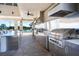 Modern outdoor grill area with stainless steel grills, countertops, and ceiling fans at 2301 Datura Loop, St Cloud, FL 34772