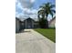 Traditional single story home featuring a large concrete driveway and mature landscaping at 233 Red Maple Dr, Kissimmee, FL 34743