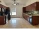 Spacious kitchen with tile floors, granite countertops, dark wood cabinets, and stainless steel appliances at 233 Red Maple Dr, Kissimmee, FL 34743