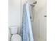 Bathroom with a toilet and a shower stall featuring a dual shower head and patterned shower curtain at 2384 Andrews Valley Dr, Kissimmee, FL 34758