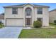 Two-story home showcasing a manicured lawn, neutral stucco, and a spacious two-car garage at 2384 Andrews Valley Dr, Kissimmee, FL 34758