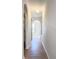 Hallway with wood flooring, arched doorways, and neutral paint, leading to additional rooms at 2384 Andrews Valley Dr, Kissimmee, FL 34758