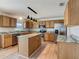 Bright kitchen features stainless steel appliances, central island, granite countertops, and lots of wooden cabinets at 2384 Andrews Valley Dr, Kissimmee, FL 34758