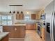 Well-lit kitchen featuring light wood cabinets, granite countertops, and a modern stainless steel refrigerator at 2384 Andrews Valley Dr, Kissimmee, FL 34758