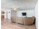 Inviting living room features wood-look floors, a ceiling fan, and a leather sofa with access to other rooms at 2384 Andrews Valley Dr, Kissimmee, FL 34758