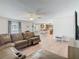 The living room connects the kitchen and backyard, featuring wood floors, ceiling fans and comfortable seating at 2384 Andrews Valley Dr, Kissimmee, FL 34758