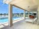 A covered patio with both lounge seating and dining, overlooking a pool and lake at 2384 Andrews Valley Dr, Kissimmee, FL 34758