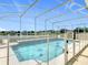 A screened-in pool with a safety fence offers picturesque views of the lake at 2384 Andrews Valley Dr, Kissimmee, FL 34758