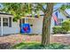A swing hangs from a mature tree in the front yard of this charming home with an American flag at 2450 Mcintosh Way, Maitland, FL 32751