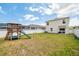 Spacious backyard with playset, white fence, and lush lawn, ideal for Gathering fun at 266 Caryota Ct, New Smyrna Beach, FL 32168