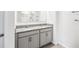Modern bathroom vanity boasts dual sinks, granite countertops, and stylish gray cabinetry at 266 Caryota Ct, New Smyrna Beach, FL 32168