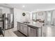 Bright kitchen with stainless steel appliances, granite countertops, a central island, and an adjacent dining area at 266 Caryota Ct, New Smyrna Beach, FL 32168