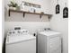 Well-lit laundry room with modern washer and dryer, plus shelving for storage and decor at 266 Caryota Ct, New Smyrna Beach, FL 32168