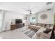 Comfortable living room with tile floors, a ceiling fan, a sectional sofa, and natural light at 266 Caryota Ct, New Smyrna Beach, FL 32168