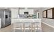 Bright kitchen features stainless steel appliances, modern white cabinetry, and a central island with stool seating at 2705 Trinidad Rd, Haines City, FL 33844