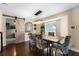 Charming dining room with a modern chandelier, rustic table, and barn door access to another room at 2801 Plaza Terrace Dr, Orlando, FL 32803