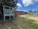 Green backyard featuring a brick wall and wooden fence at 307 Hollingshead Loop, Davenport, FL 33896