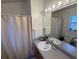 Well-lit bathroom with a single sink vanity and shower-tub combo at 307 Hollingshead Loop, Davenport, FL 33896