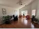A living room with hardwood floors, a ceiling fan, three windows, and three chairs at 307 Hollingshead Loop, Davenport, FL 33896