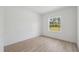 A naturally lit bedroom featuring wood-look floors and a window offering outdoor views at 3072 Sw 168Th Loop, Ocala, FL 34473