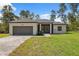 Inviting one-story home with a neat lawn and a paved driveway to the attached garage at 3072 Sw 168Th Loop, Ocala, FL 34473