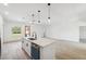 Modern kitchen island with white countertops, stylish lighting, and open sightlines to living areas at 3072 Sw 168Th Loop, Ocala, FL 34473