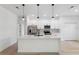 Bright, white kitchen features stainless steel appliances, quartz island and pendant lighting at 3072 Sw 168Th Loop, Ocala, FL 34473