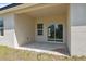 A covered patio area with a concrete floor, window and sliding glass door, perfect for outdoor relaxation at 3072 Sw 168Th Loop, Ocala, FL 34473