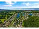 Aerial view showcasing a Primary-planned community with multiple lakes, lush greenery, and tree-lined streets at 3078 Mandolin Dr, Kissimmee, FL 34744