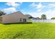 Backyard view showcasing a large grassy area, white fence, and the home's exterior at 3078 Mandolin Dr, Kissimmee, FL 34744