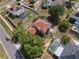 Aerial view of a home with a red roof featuring a screened pool and well manicured landscaping at 3216 White Blossom Ln, Clermont, FL 34711