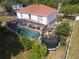 An aerial view showcasing the large, screened-in pool, spacious yard, and mature trees at 3216 White Blossom Ln, Clermont, FL 34711