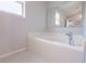 Clean and modern bathtub with a silver faucet and light tile flooring at 3216 White Blossom Ln, Clermont, FL 34711