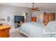 Bedroom featuring a wooden bed frame, ceiling fan, and neutral gray walls, creating a cozy space at 3216 White Blossom Ln, Clermont, FL 34711