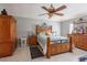Bedroom with a wooden bed frame, ceiling fan, and neutral gray walls at 3216 White Blossom Ln, Clermont, FL 34711