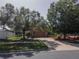 A landscaped front yard, with mature trees lining the long driveway at 3216 White Blossom Ln, Clermont, FL 34711
