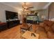Comfortable living room with hardwood floors, ceiling fan, and a fish tank at 3216 White Blossom Ln, Clermont, FL 34711