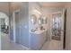Bright main bathroom with double sinks, stylish fixtures, modern lighting and walk-in shower at 3216 White Blossom Ln, Clermont, FL 34711