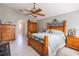 Cozy main bedroom featuring a ceiling fan, warm wood accents, and archway to the ensuite bathroom at 3216 White Blossom Ln, Clermont, FL 34711