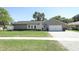 Charming single-story home with a well-manicured lawn and a gray exterior with stone accents at 347 Timberwood Trl, Oviedo, FL 32765