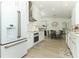 Modern kitchen boasts white cabinets, stainless steel appliances, and a view into the dining area at 347 Timberwood Trl, Oviedo, FL 32765
