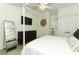 Well-lit main bedroom featuring a four-poster bed, mounted TV, full-length mirror, and dark dresser at 347 Timberwood Trl, Oviedo, FL 32765