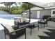 Enjoy comfortable seating around a coffee table in this covered outdoor lounge area by the pool at 347 Timberwood Trl, Oviedo, FL 32765