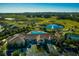 Aerial view showcasing the community clubhouse, pool, landscaping, and surrounding golf course and ponds at 3755 Sanibel St, Clermont, FL 34711