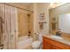 Well-lit bathroom featuring granite countertop, wood cabinet, and a shower with coordinated tile and fixtures at 3755 Sanibel St, Clermont, FL 34711