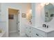 Bright bathroom with double vanity, white cabinets, framed mirror, and marble floors at 3755 Sanibel St, Clermont, FL 34711