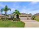 Charming single-story home with a three-car garage, a well-manicured lawn and mature tropical landscaping at 3755 Sanibel St, Clermont, FL 34711