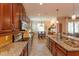 Another angle of the spacious kitchen with granite countertops and wood cabinetry leading to the dining area at 3755 Sanibel St, Clermont, FL 34711