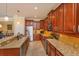 A view of the kitchen featuring wood cabinetry, granite countertops, stainless appliances, and a breakfast bar at 3755 Sanibel St, Clermont, FL 34711