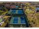 Aerial shot of a community's tennis courts and putting green surrounded by palm trees and greenery at 3755 Sanibel St, Clermont, FL 34711